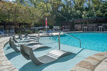 A pool with a red flag and lounge chairs.
